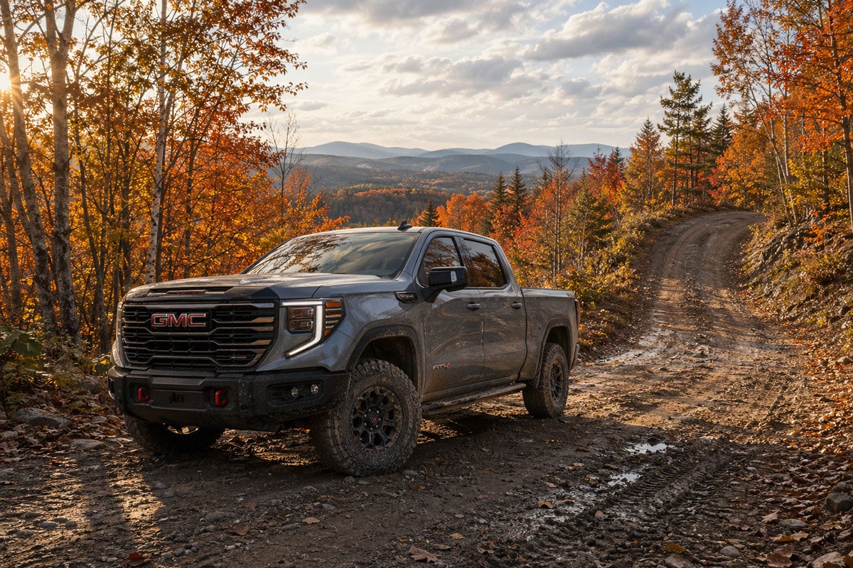 2026 GMC Sierra 1500 AT4X on a rural western Maine logging road with peak fall foliage
