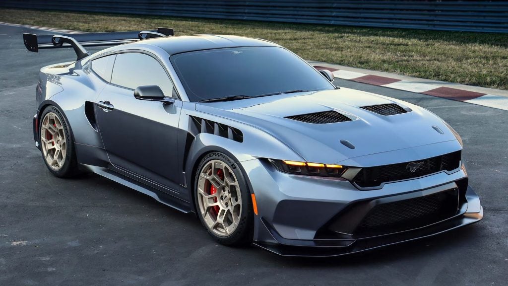 2025 Ford Mustang parked on a racetrack, showcasing its aggressive aerodynamic design, performance styling, and modern muscle car appeal.