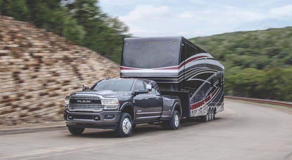 A black 2020 Ram 3500 HD is shown towing a trailer home.