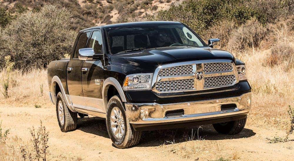 A black 2017 Ram 1500 is shown from the front parked on a dirt path.
