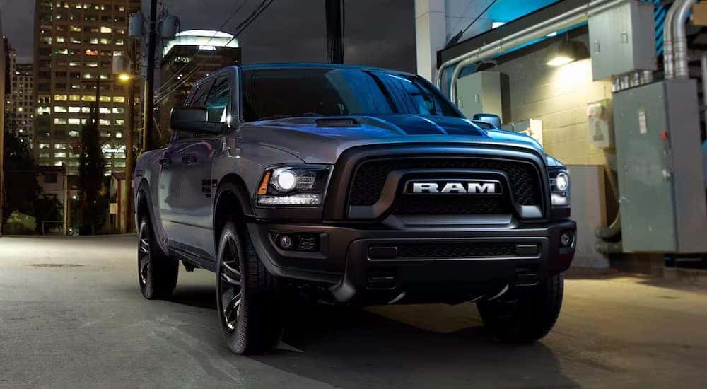 A black 2023 Ram 1500 Classic parked in a city alleyway after visiting a dealer with a Ram 1500 for sale near Lawrenceburg.