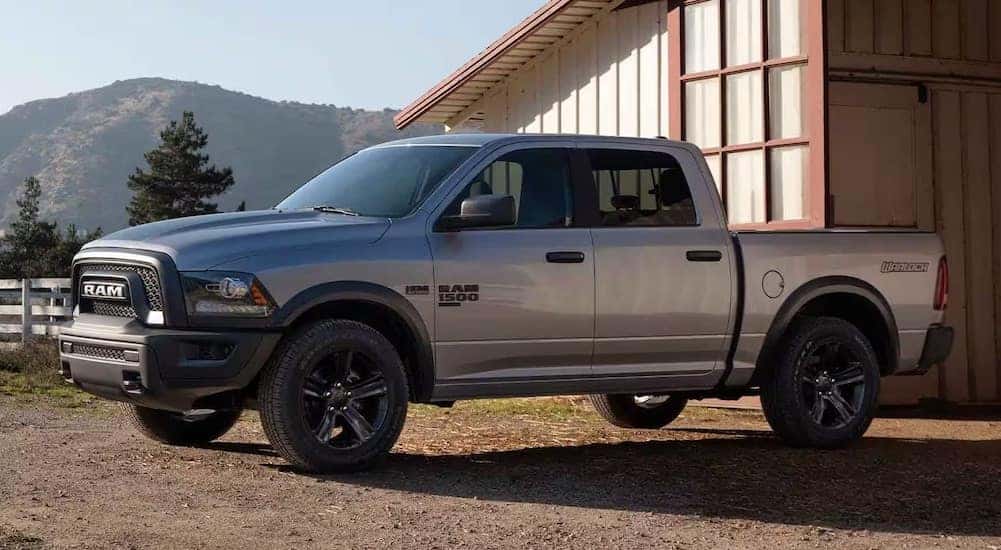 A white 2023 Ram 1500 Classic Warlock parked on a farm.