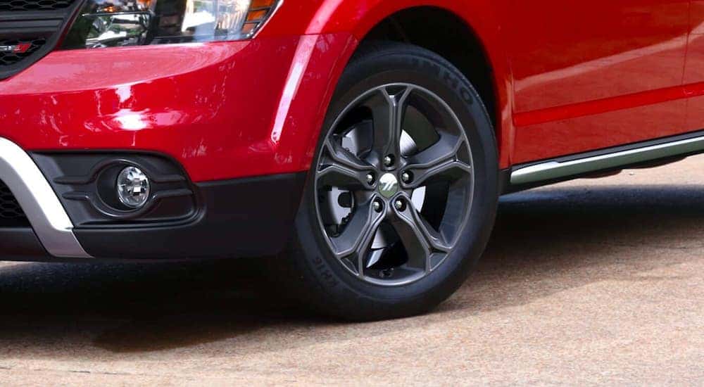A close up shows the wheel on a red 2020 used Dodge Journey.