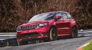 A red 2020 used Jeep Grand Cherokee Trackhawk is shown on the race track.