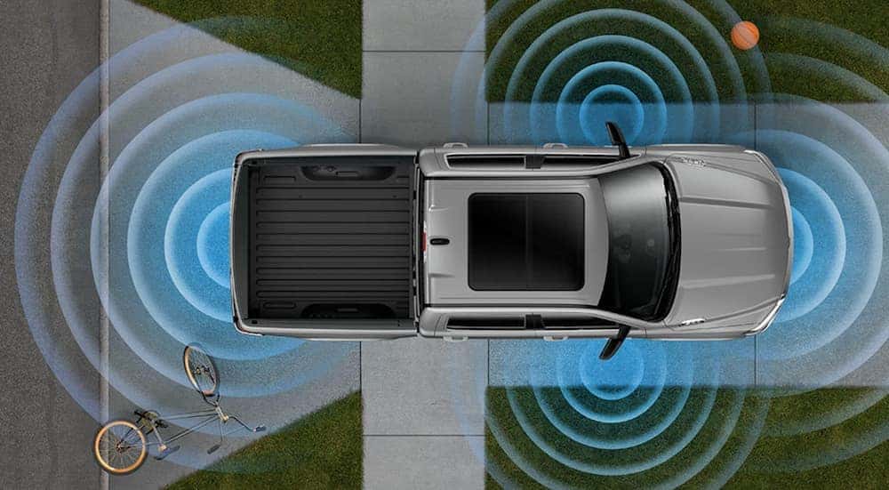 A diagram shows a silver 2019 Ram 1500 from above using blind spot detection in a driveway.