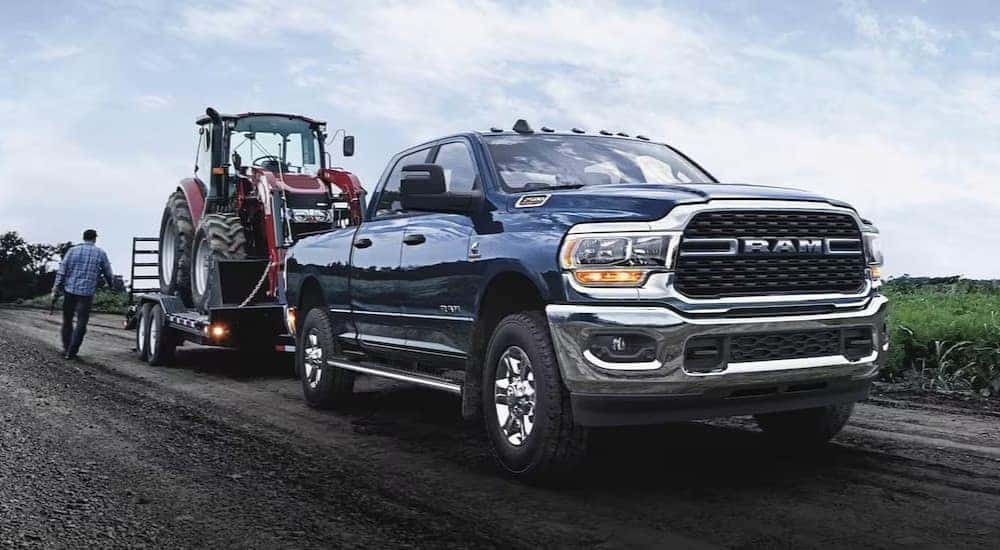 A blue 2023 Ram 2500 Laramie is shown towing a trailer after visiting a Ram dealer near Shelbyville.
