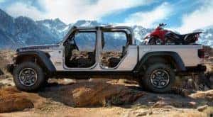 A silver 2020 used Jeep Gladiator Rubicon is shown from the side with no doors in the mountains.