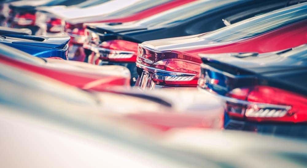 Rows of used cars are shown with a focus on the trunks.