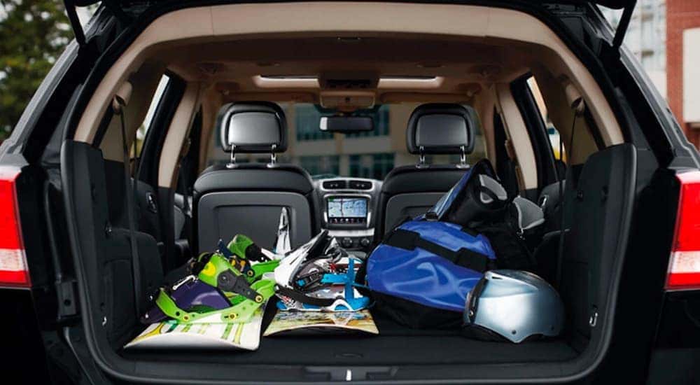 A close up shows the open trunk full of snowboarding gear in a 2020 Dodge Journey.