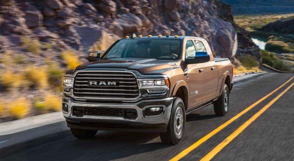 A brown 2019 used Ram 2500 is driving on a rocky highway.