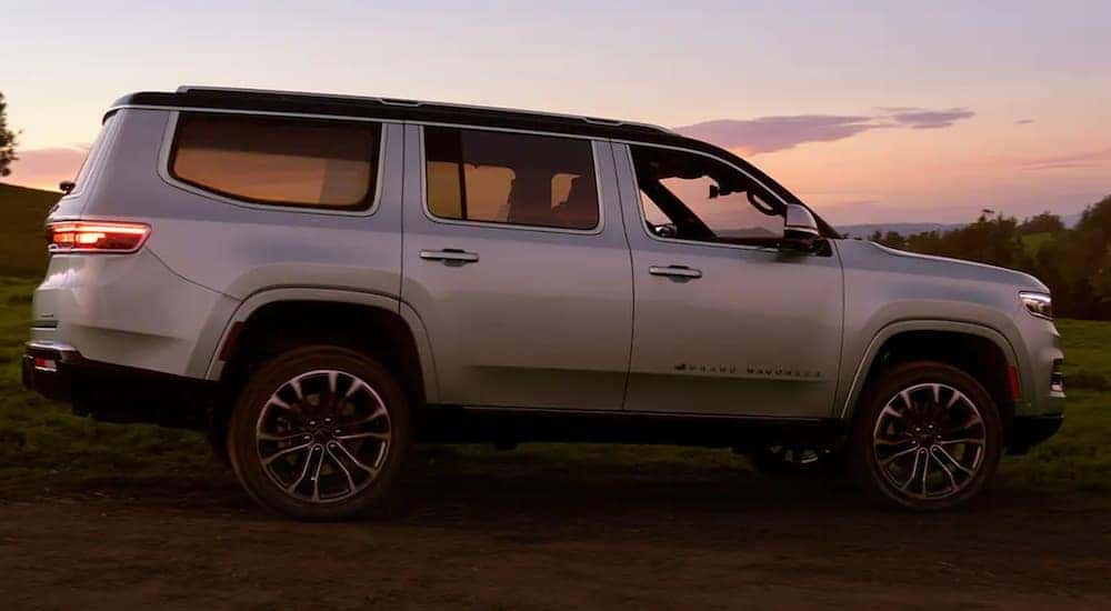 A white 2022 Grand Wagoneer is shown from the side parked at sunset.