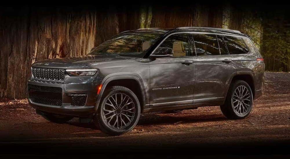 A gray 2024 Jeep Grand Cherokee for sale is shown parked off-road.