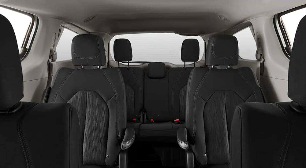 That black interior and rear seating is shown in a 2021 Chrysler Voyager.