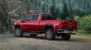 A red 2020 GMC Sierra 2500 is shown from the rear parked in the forest.