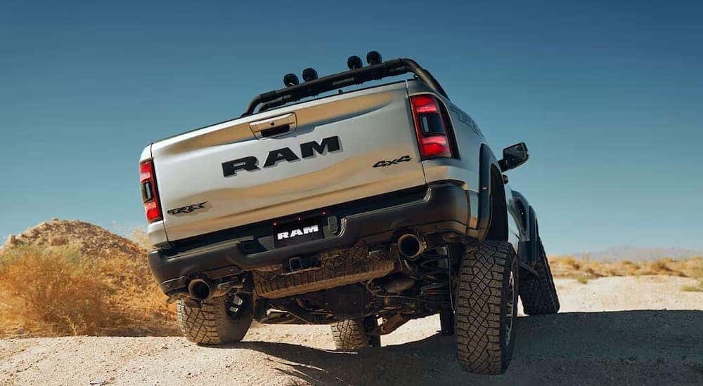 A silver 2023 Ram 1500 TRX is shown from the rear while off-road after leaving a Ram dealer.