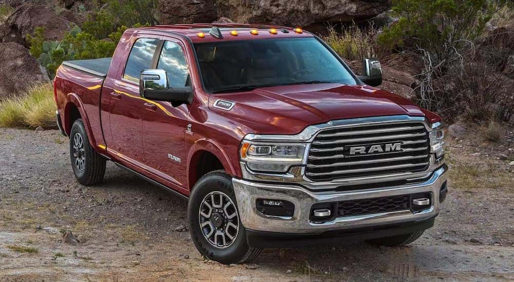 A red 2024 Ram 2500 Limited Longhorn is shown from the front at an angle after leaving a dealer that has a RAM 2500 for sale near Covington.