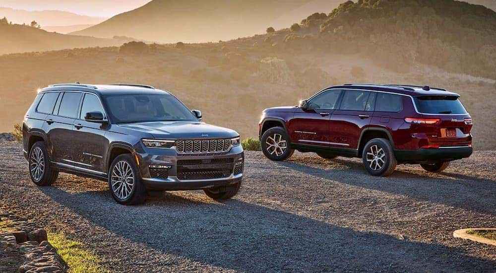 A grey 2024 Jeep Grand Cherokee Summit and a red 2024 Jeep Grand Cherokee Limited parked in the desert.