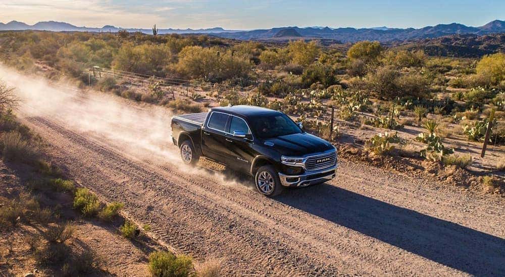 A black 2019 Ram 1500 is shown from a high angle driving down a dirt path.