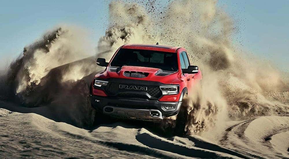 A red 2021 Ram 1500 TRX is off-roading through a sandy desert.