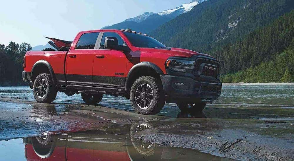 A red 2024 Ram 2500 Rebel is shown from the side while parked off-road.