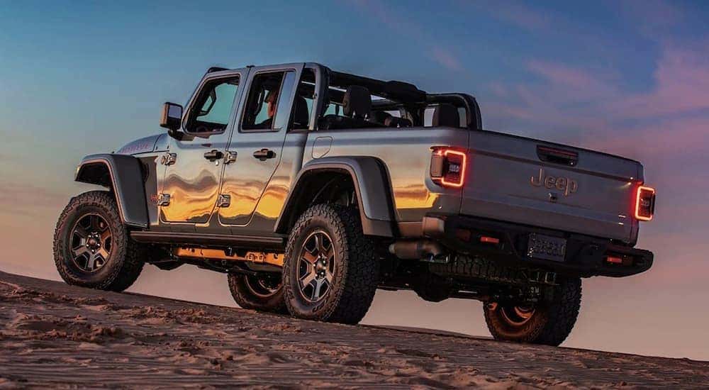 A silver 2023 Jeep Gladiator Mojave is shown parked off-road after visiting a used Jeep dealership.