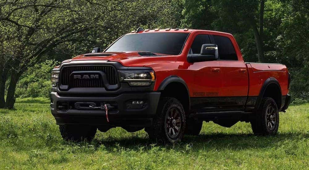 A red 2024 Ram 2500 HD Power Wagon is shown from the front at an angle after leaving a dealer that has a Ram 2500 for sale.