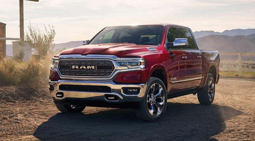A red 2019 Ram 1500 is shown parked near a farm.