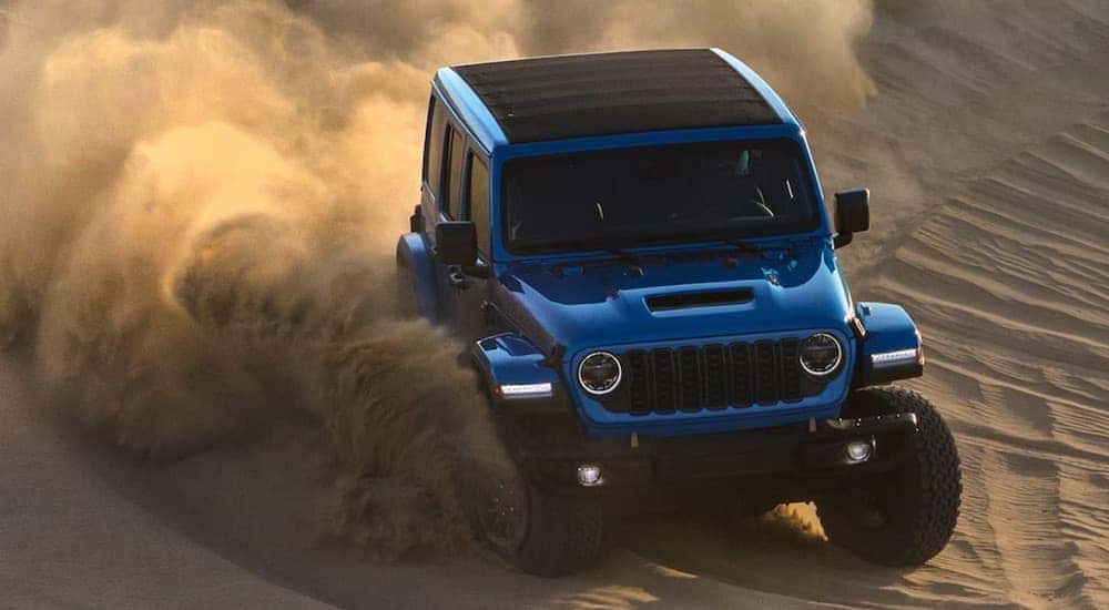 A blue 2024 Jeep Wrangler Rubicon 392 is shown from the front at an angle.