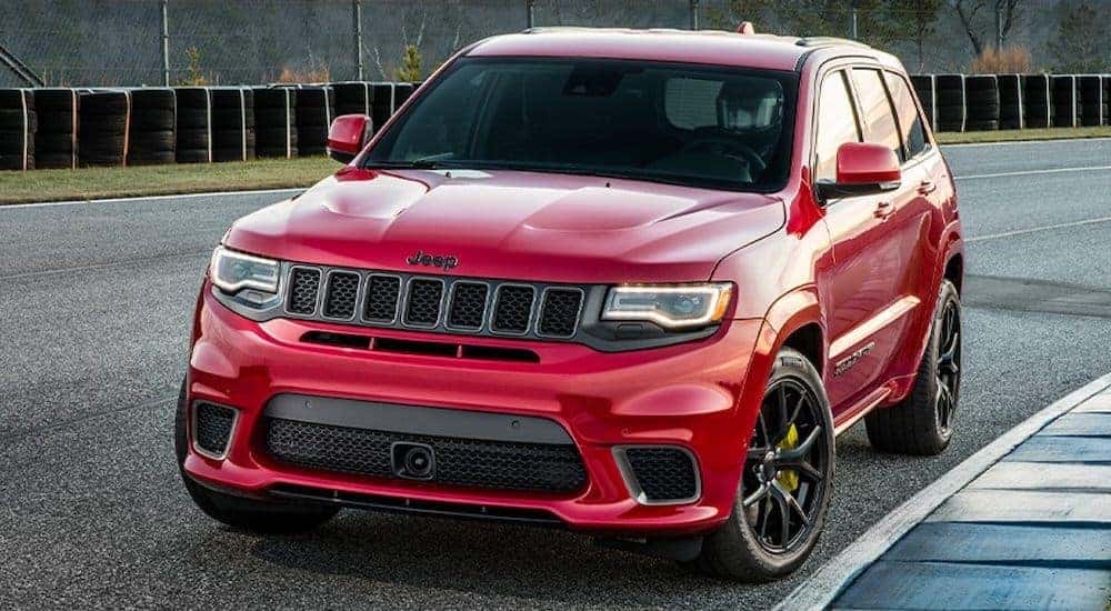 A red 2017 used Jeep Grand Cherokee Trackhawk is driving around the racetrack.