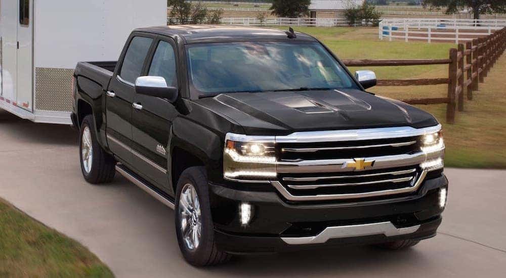 A black 2018 Chevy Silverado 1500 is towing a trailer.