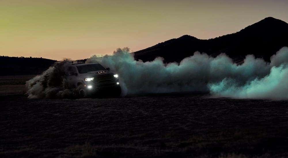 A grey 2021 Ram 1500 TRX is shown doing burnouts in the dunes after leaving a used Ram dealership in KY.