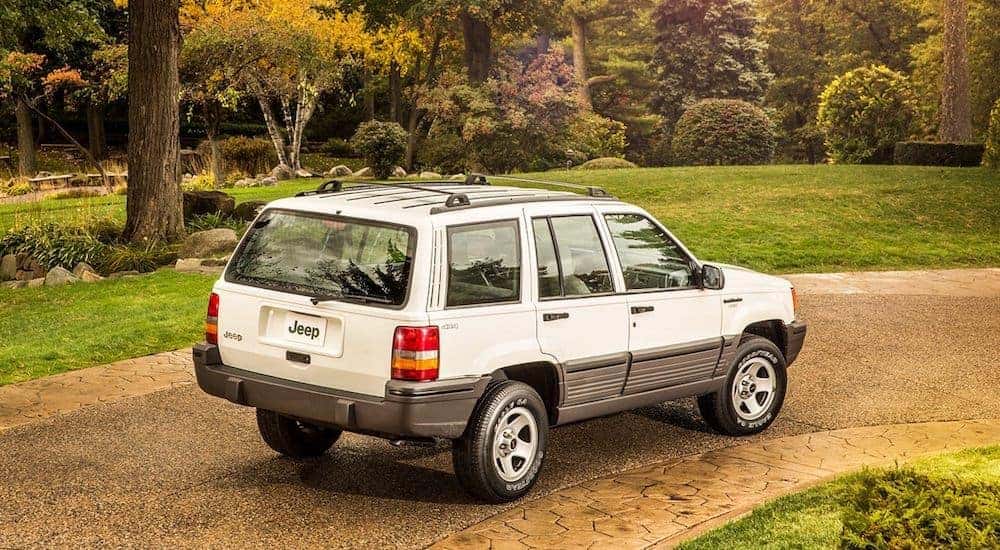 A white 2003 used Jeep Grand Cherokee is shown from behind angled right.