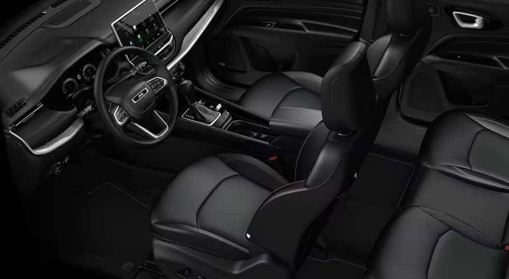 The black interior and dash of a 2024 Jeep Compass is shown.