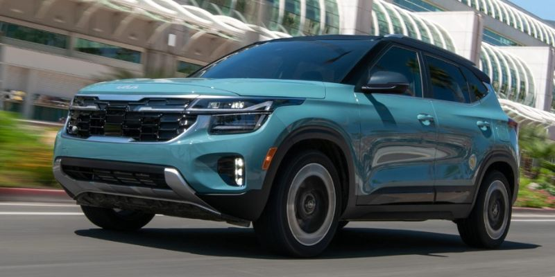 A blue SUV travels swiftly on a city street with a modern building backdrop. The car's sleek design and dynamic motion convey a sense of innovation and speed.