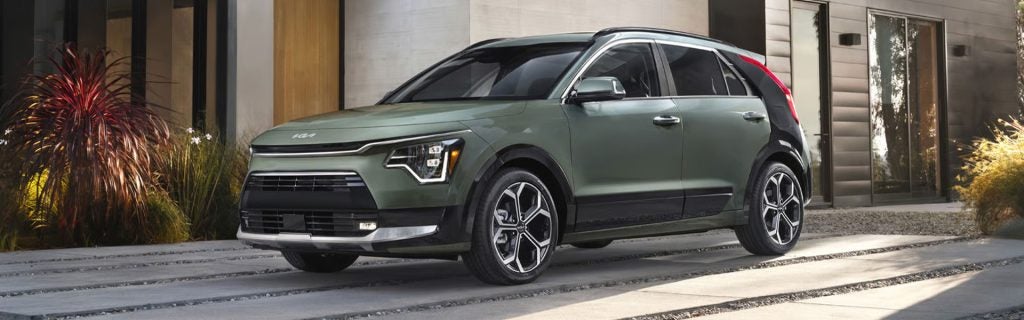 Green SUV parked in a modern driveway outside a contemporary home.