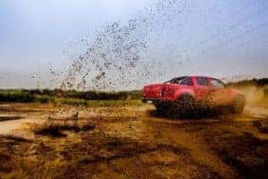 a Red Silverado treading in mud