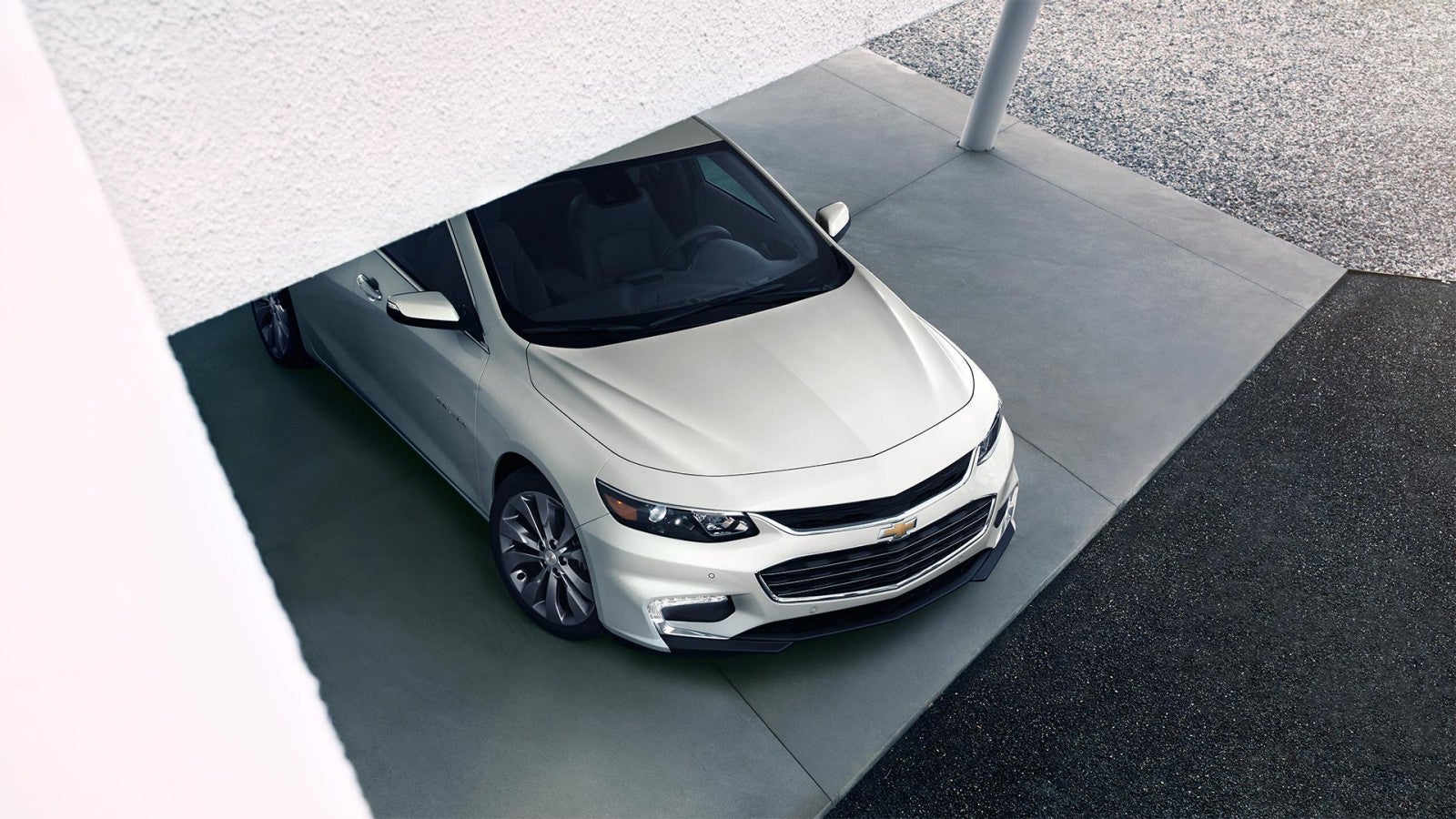 White Chevrolet Malibu emerging from a parking garage