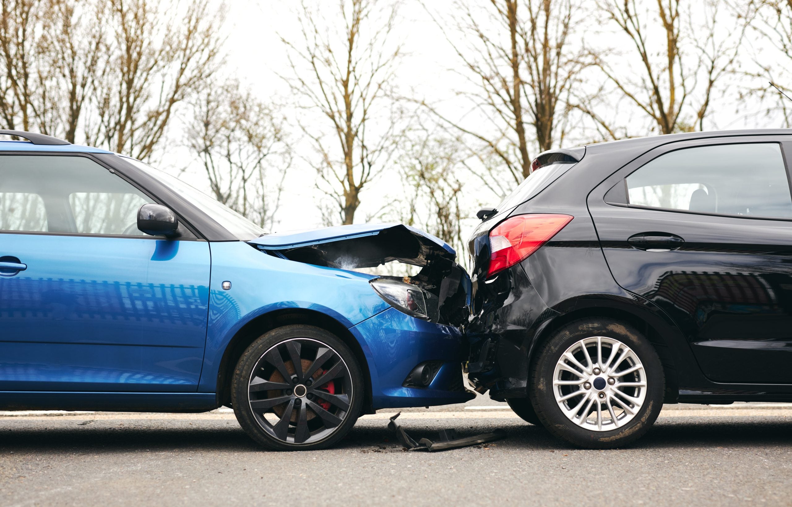 A blue and black car involved in a collision, with visible damage to the front and rear ends of both vehicles