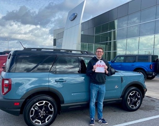 Dealer holding SOLD sign