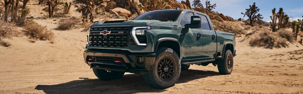 2026 Chevrolet Silverado HD truck driving on sandy terrain