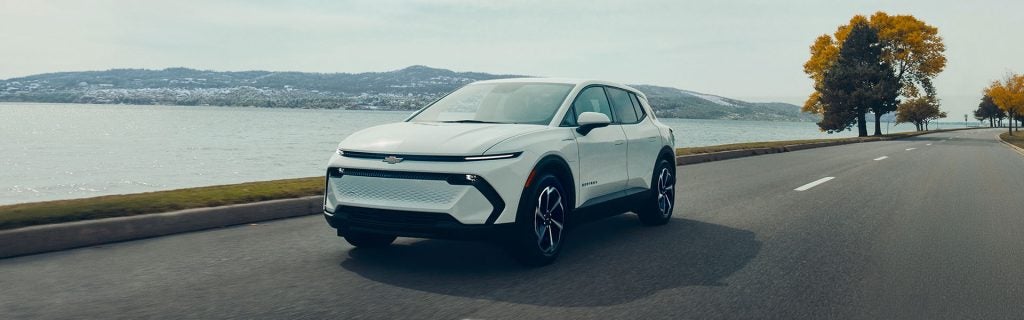 2026 Chevrolet Equinox EV driving along a scenic coastal road 