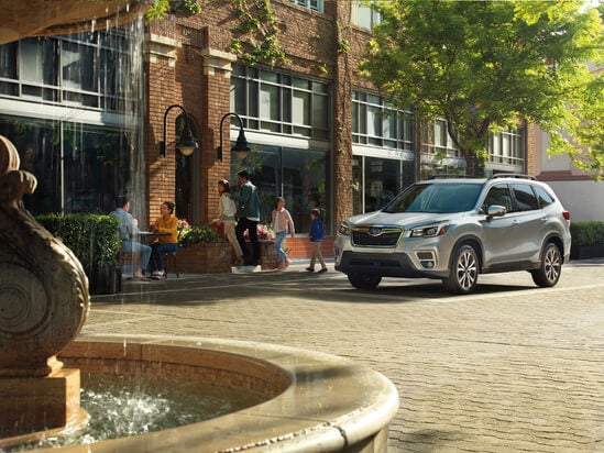 A silver Subaru Forester in front of a building