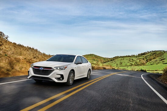 A Subaru driving in front of hills