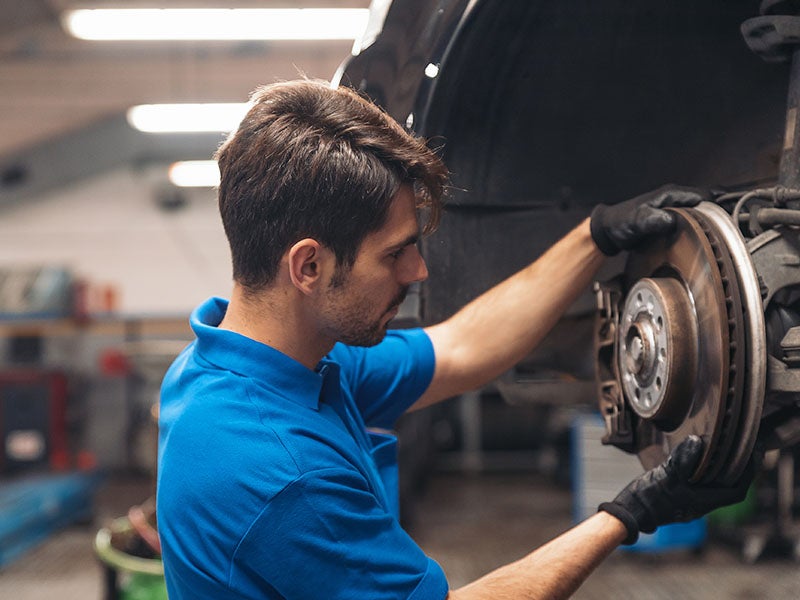 technician working on the brakes of a Subaru