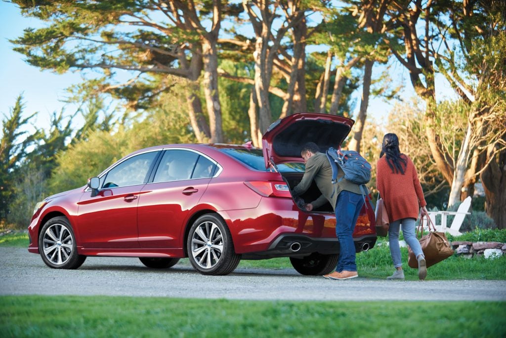 couple loading their Subaru trunk on a sunny morning