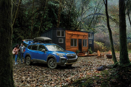 couple unloading their Subaru next to their tiny home