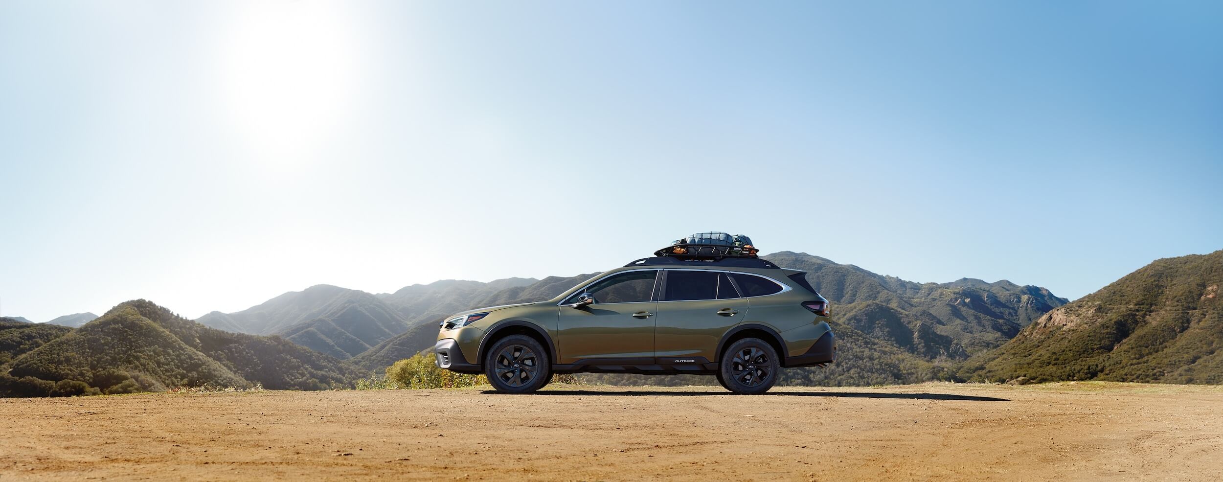 A Subaru Outback in front of hills
