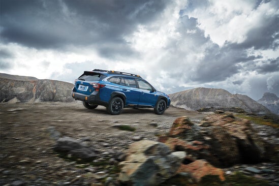 A blue Subaru Outback in the mountains