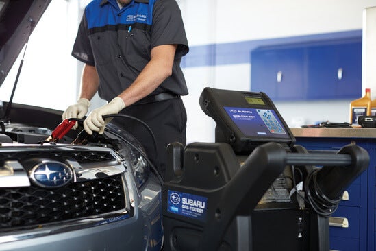 A mechanic servicing a Subaru