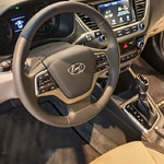Close-up of a car interior showcasing a modern dashboard with a touchscreen display, steering wheel with controls, and manual gearshift, conveying a sleek, high-tech design.